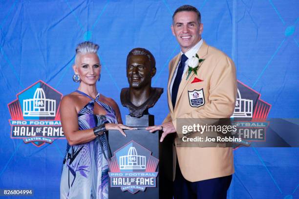 Kurt Warner and wife Brenda Warner pose his bust during the Pro Football Hall of Fame Enshrinement Ceremony at Tom Benson Hall of Fame Stadium on...