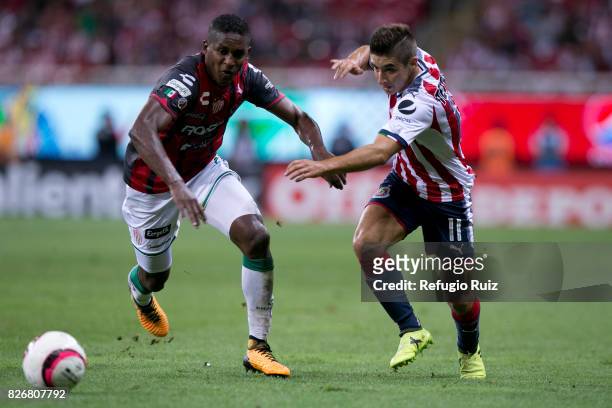 Isaac Brizuela of Chivas fights for the ball with Brayan Beckeles of Necaxa during the third round match between Chivas and Necaxa as part of the...