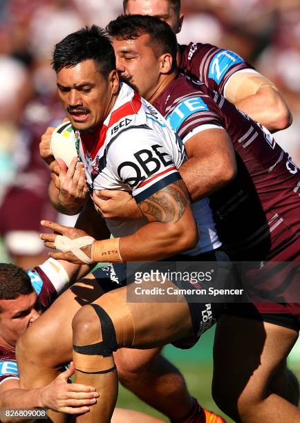 Zane Tetevano of the Roosters is tackled during the round 22 NRL match between the Manly Warringah Sea Eagles and the Sydney Roosters at Lottoland on...