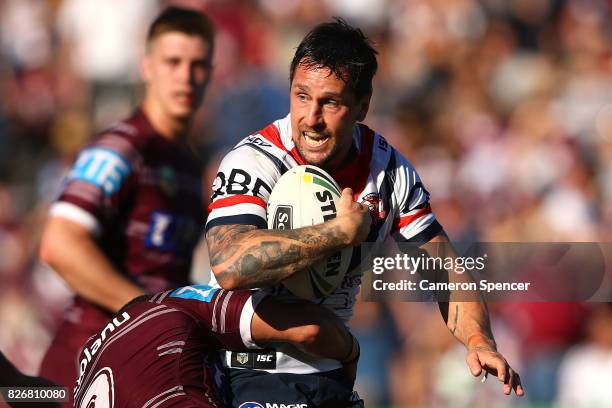 Mitchell Pearce of the Roosters is tackled during the round 22 NRL match between the Manly Warringah Sea Eagles and the Sydney Roosters at Lottoland...