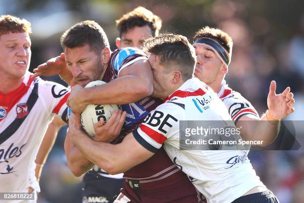 Lewis Brown of the Sea Eagles is tackled during the round 22 NRL match between the Manly Warringah Sea Eagles and the Sydney Roosters at Lottoland on...