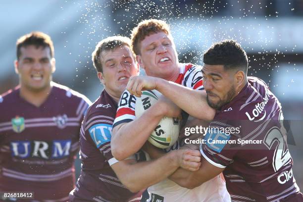 Dylan Napa of the Roosters is tackled during the round 22 NRL match between the Manly Warringah Sea Eagles and the Sydney Roosters at Lottoland on...