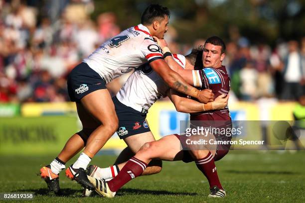 Darcy Lussick of the Sea Eagles is tackled during the round 22 NRL match between the Manly Warringah Sea Eagles and the Sydney Roosters at Lottoland...