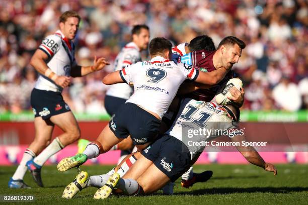 Lewis Brown of the Sea Eagles is tackled during the round 22 NRL match between the Manly Warringah Sea Eagles and the Sydney Roosters at Lottoland on...