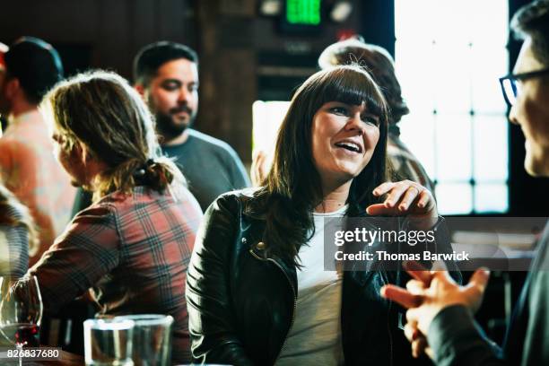 laughing woman in discussion with man while hanging out in bar - romantische aktivität stock-fotos und bilder