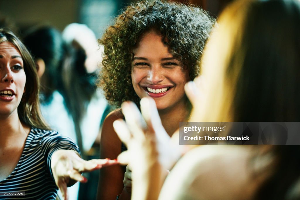 Laughing woman hanging out with friends in bar