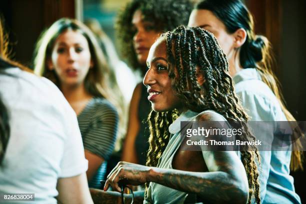 smiling woman in discussion with friends in bar - local bar stock pictures, royalty-free photos & images