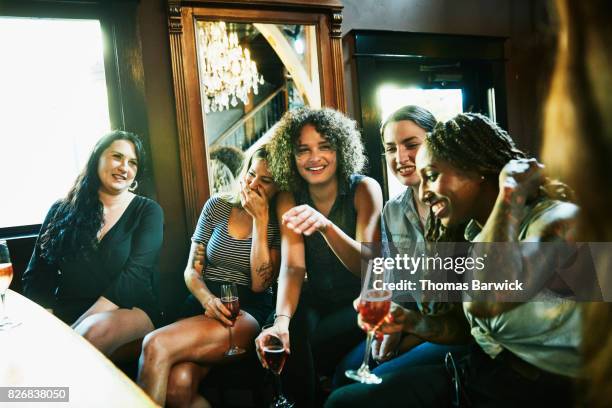 laughing group of female friends sharing drinks in bar - ladies night stock pictures, royalty-free photos & images