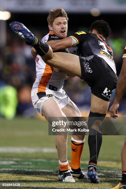 Chris Lawrence of the Tigers tackled by Corey Harawira-Naera of the Panthers during the round 22 NRL match between the Penrith Panthers and the Wests...