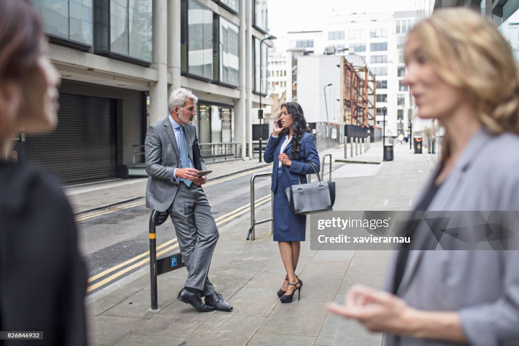 Business People Talking While Standing On Footpath High-Res Stock Photo ...