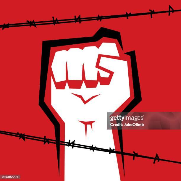 fist behind barbed wire - barbed wire fence stock illustrations