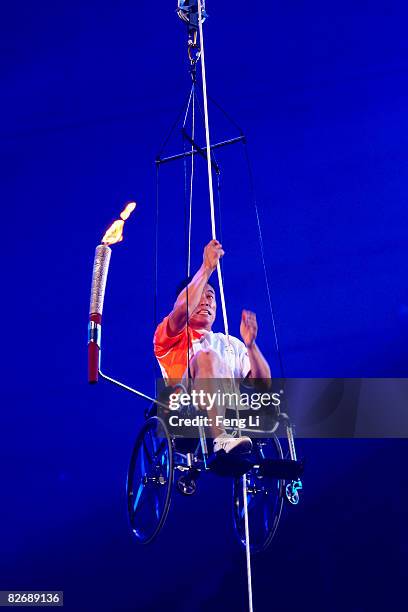 Chinese Paralympic athlete Hou Bin draws himself to the main torch during the Opening Ceremony for the 2008 Paralympic Games at the National Stadium...