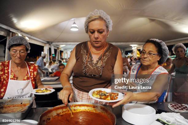 Volunteer in the kitchen prepares pasta and fish at the Festa dell'Unita after Italian politician Matteo Renzi, Secretary of the Democratic Party...