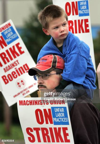 Boeing machinist Scott Green, with his son Joshua on his shoulders, walks the picket line outside Boeing's plant September 6, 2008 in Everett,...