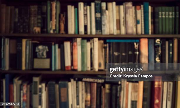 defocused image of bookshelf - literature ストックフォトと画像