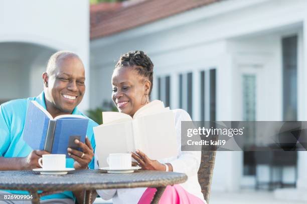 senior afro-amerikaanse paar op terras, lezen - early retirement stockfoto's en -beelden