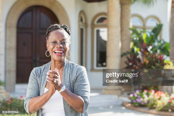 senior african-american woman standing in front of house - african ethnicity luxury stock pictures, royalty-free photos & images