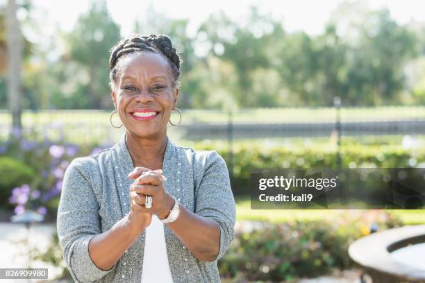 senior african-american woman standing outdoors - early retirement stock pictures, royalty-free photos & images
