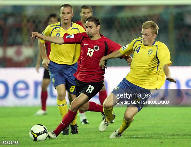 Sweden's Daniel Andersson and Sebastian Larsson vie with Albanian Ervin Skela during their World Cup 2010 qualifying match at Qemal Stafa stadium in...