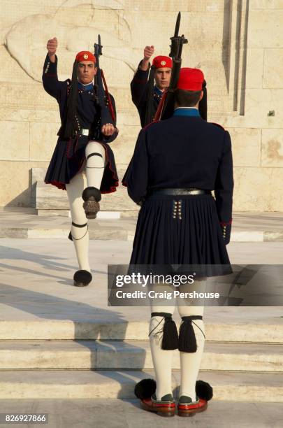 evzones (parliament house guards) marching before the tomb of the unknown soldier during the changing of the guard ceremony. - piazza syntagma stockfoto's en -beelden