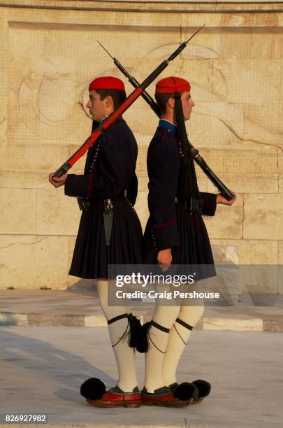 evzones (parliament house guards) standing back-to-back before the tomb of the unknown soldier in syntagma square. - piazza syntagma stockfoto's en -beelden