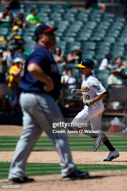 Jaycob Brugman of the Oakland Athletics rounds the bases after hitting a home run off of Bartolo Colon of the Minnesota Twins during the fifth inning...