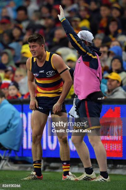 Riley Knight of the Crows is attended to by a trainer during the round 20 AFL match between the Adelaide Crows and the Port Adelaide Power at...