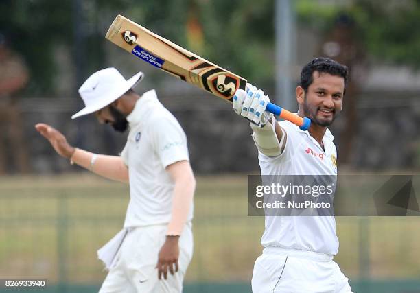 Sri Lankan cricketer Dimuth Karunaratne celebrates after scoring a century during the 4th Day's play in the 2nd Test match between Sri Lanka and...