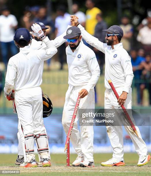 Indian captain Virat Kohli walks off with a stump in his hand after India defeated Sri Lanka by an innings and 53 runs during the 4th Day's play in...