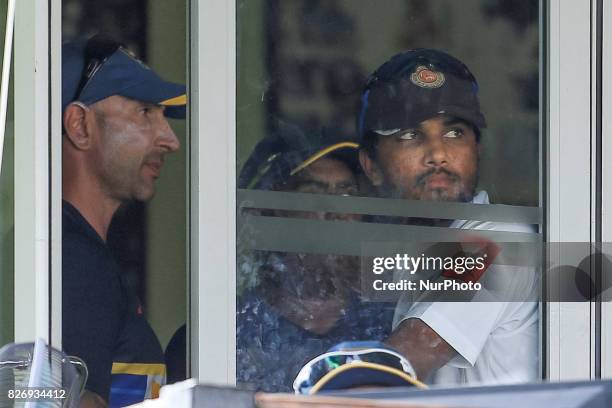 Sri Lankan captain Dinesh Chandimal and Sri Lankan Cricket's interim coach Nic Pothas look out from the window of Sri Lankan cricket team's dressing...