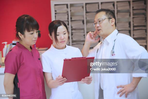 medische staf bespreken bij kliniek - 医療従事者 stockfoto's en -beelden