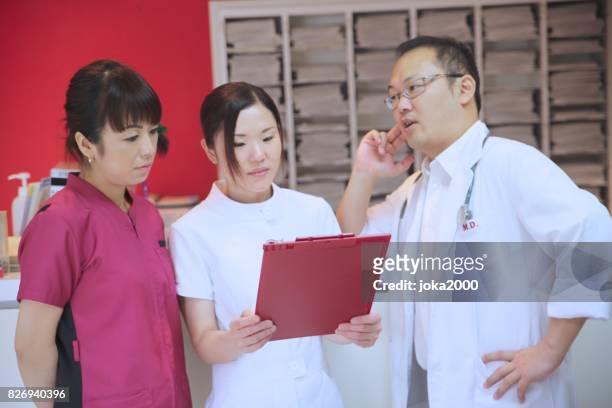 medical staffs discussing at clinic - 職場 stock pictures, royalty-free photos & images