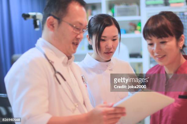 medische staf bespreken in ziekenhuis - 医療従事者 stockfoto's en -beelden