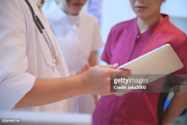 medical staffs discussing at hospital - 職場 stock pictures, royalty-free photos & images