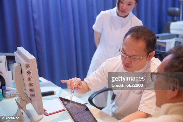 medical doctor explaning data to patient at clinic - 職場 stock pictures, royalty-free photos & images