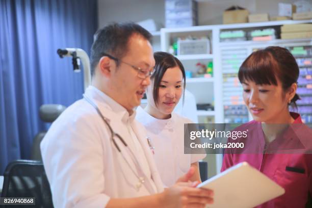 medical staffs discussing at clinic - 職場 stock pictures, royalty-free photos & images