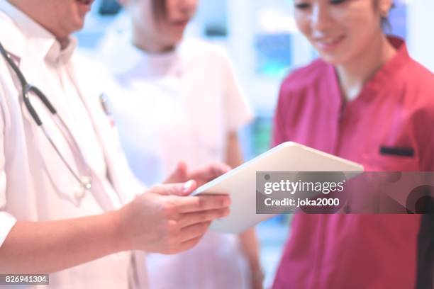 medical staffs discussing at clinic - 職場 stock pictures, royalty-free photos & images