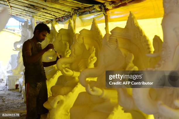 An Indian artist paints a model of the Hindu deity Ganesh ahead of the forthcoming Ganesh Chathurthi festival at a workshop in Chennai on August 6,...