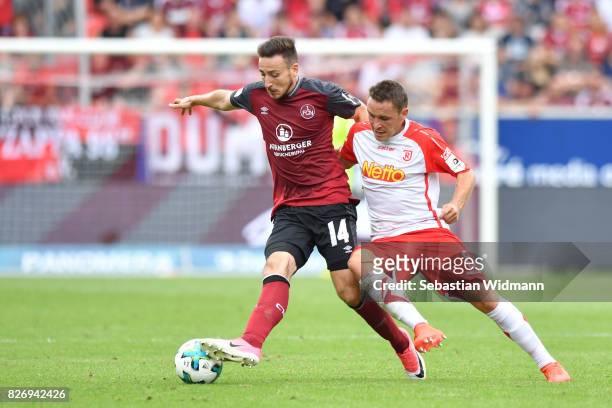 Kevin Moehwald of 1. FC Nuernberg and Andreas Geipl of SSV Jahn Regensburg compete for the ball during the Second Bundesliga match between SSV Jahn...