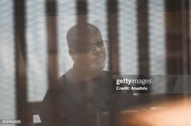 Egypts ousted President Mohamed Morsi and additional 21 defendants attend a trial session behind a cage at the Cairo Police Academy in Cairo, Egypt...