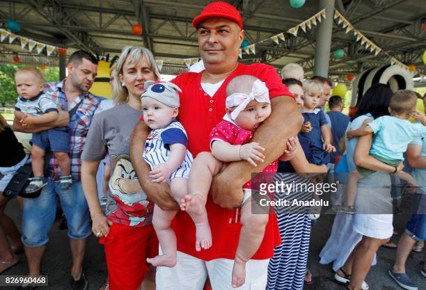 Parents of baby twins attend "Double Happiness" with their babies at the National Complex within "Expocenter of Ukraine" in Kiev, Ukraine, on August...