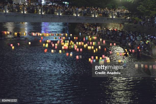 People attend the Peace Message Lantern Floating Ceremony held to console the souls of the A-Bomb victims after the Hiroshima Peace Memorial Ceremony...