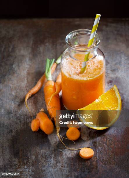 carrot and orange juice on rustic wooden table top. - tangerine 2015 film stock-fotos und bilder