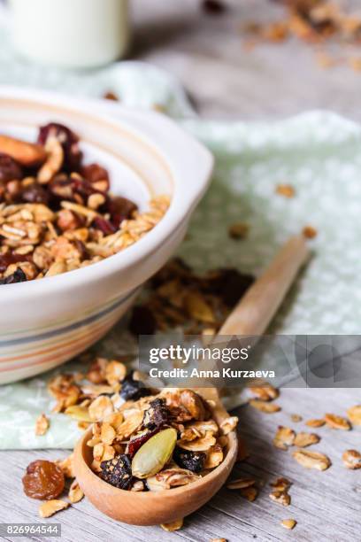homemade granola or muesli with toasted almonds, raisin, cranberry in a bowl for healthy breakfast, selective focus - gedroogd fruit stockfoto's en -beelden