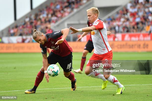 Rurik Gislason of 1. FC Nuernberg and Alexander Nandzik of SSV Jahn Regensburg compete for the ball during the Second Bundesliga match between SSV...