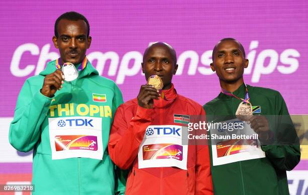 Tamirat Tola of Ethiopia poses with the silver medal, Geoffrey Kipkorir Kirui of Kenya poses with the gold medal and Alphonce Felix Simbu of Tanzania...