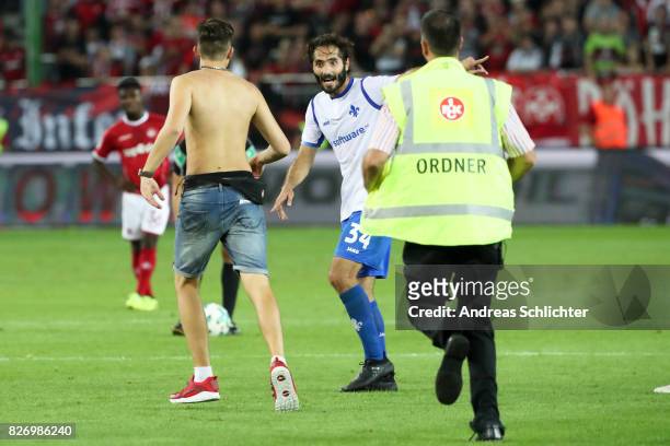 A streaker of kaiserslautern and Hamit Altintop of Darmstadt during the Second Bundesliga match between 1. FC Kaiserslautern and SV Darmstadt 98 at...