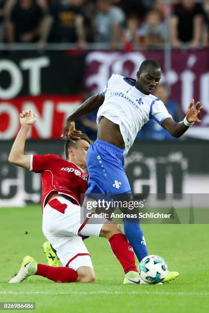Wilson Kamavuaka of Darmstadt challenges Gino Fechner of Kaiserslautern during the Second Bundesliga match between 1. FC Kaiserslautern and SV...
