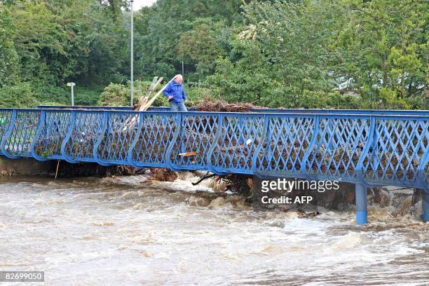 Resident crosses the Green Bridge over the Wansbeck River in the aftermath of flooding in Morpeth, north-eastern England, on September 7, 2008. AFP...