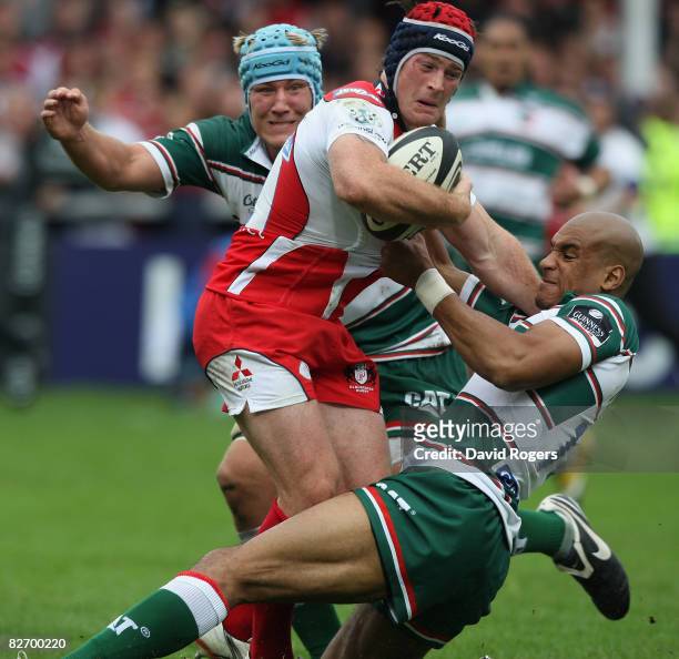 Andy Titterrell of Gloucester is tackled by Jordan Crane and Tom Varndell during the Guinness Premiership match between Gloucester and Leicester...